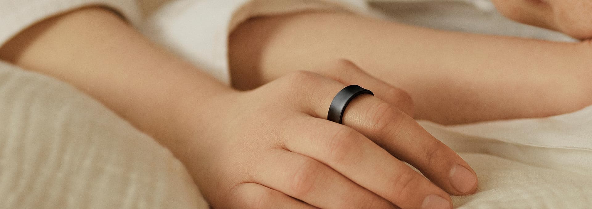 A hand wearing Galaxy Ring in bed can be seen.